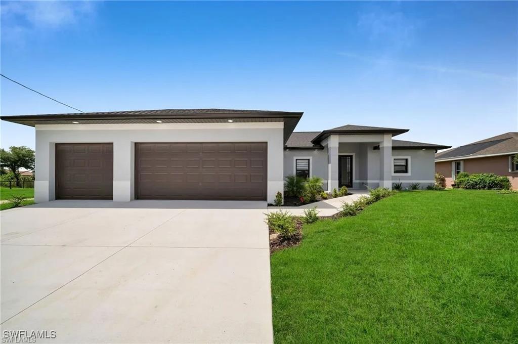 Prairie-style home featuring stucco siding, a front yard, and concrete driveway