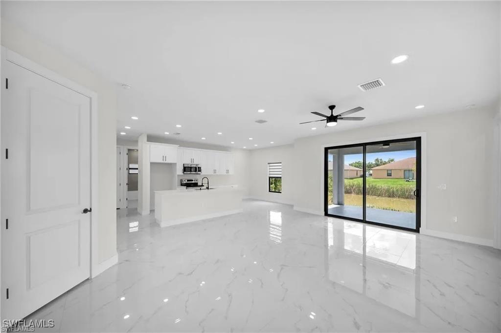 Unfurnished living room featuring recessed lighting, light marble finish floors, and ceiling fan