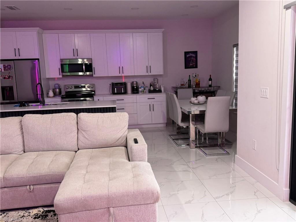 Living area with baseboards and light marble finish flooring
