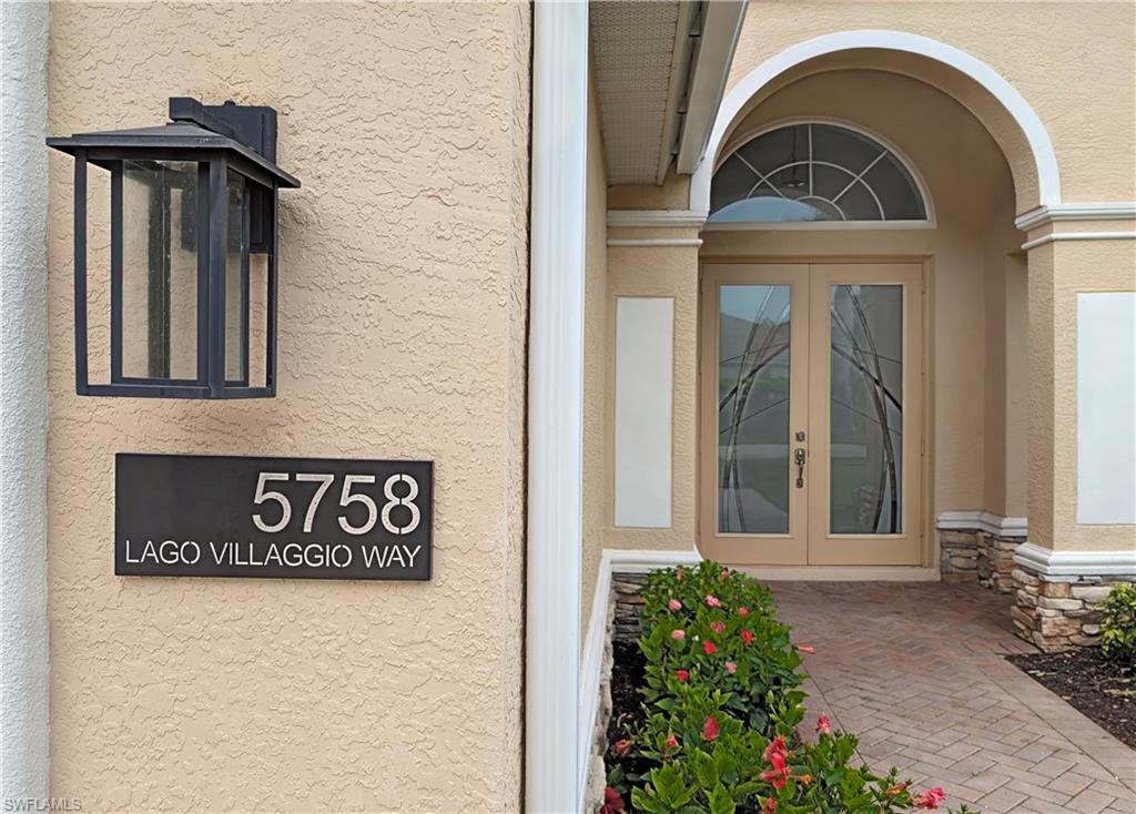 Doorway to property featuring stucco siding, stone siding, and french doors