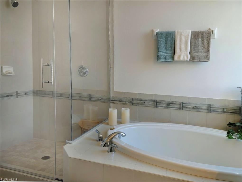Bathroom featuring shower with separate bathtub