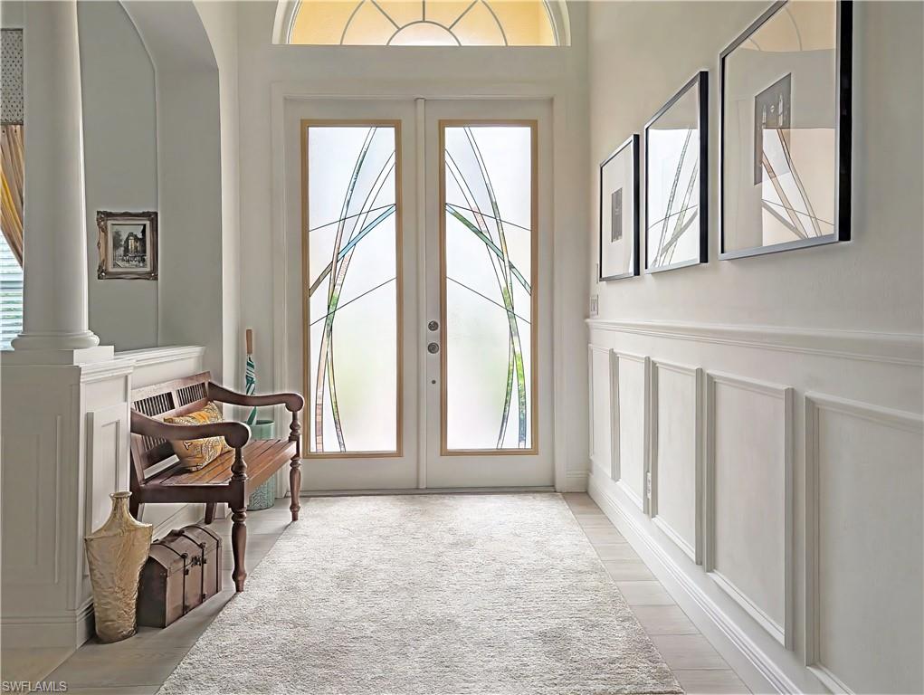 Entryway featuring a decorative wall, french doors, and a wainscoted wall