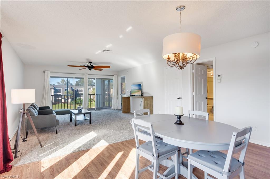 Dining room featuring a ceiling fan, light wood-type flooring, and a chandelier