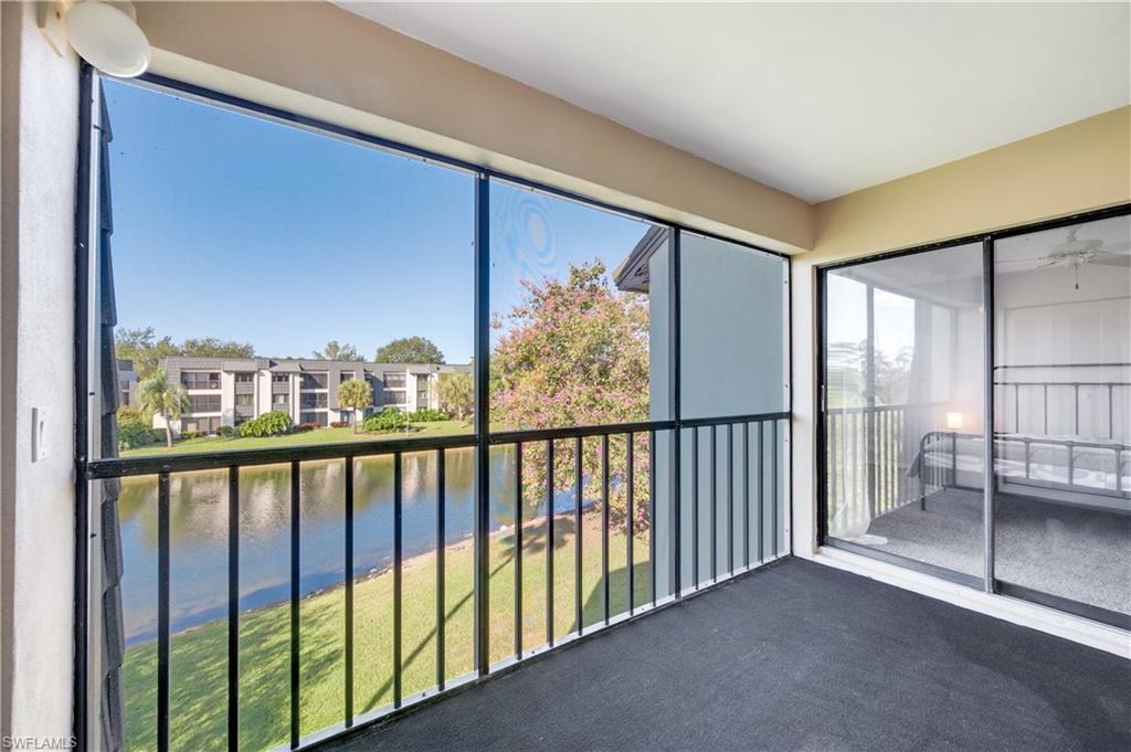 Unfurnished sunroom with a balcony, a ceiling fan, a water view, and plenty of natural light