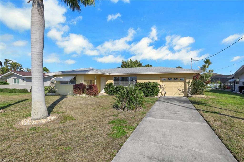 Single story home with a front lawn, driveway, an attached garage, and stucco siding
