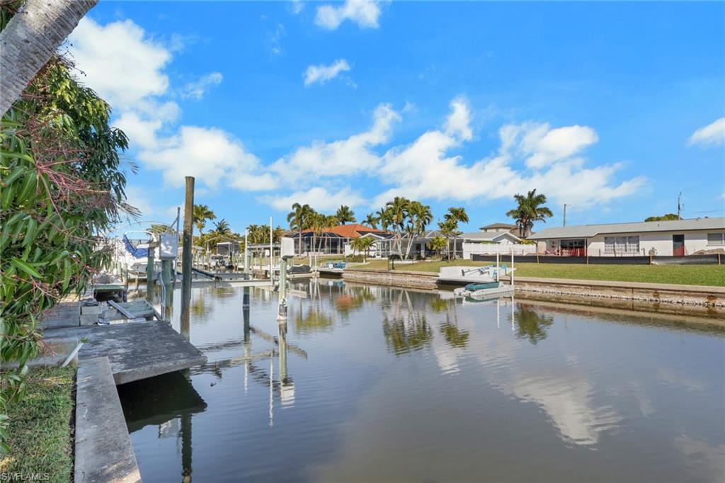 Dock with a water view, boat lift, and a residential view