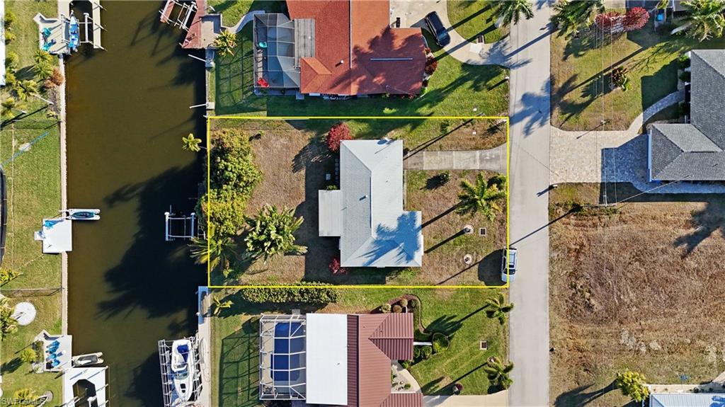 Aerial view of residential area with a large body of water and property parcel outlined