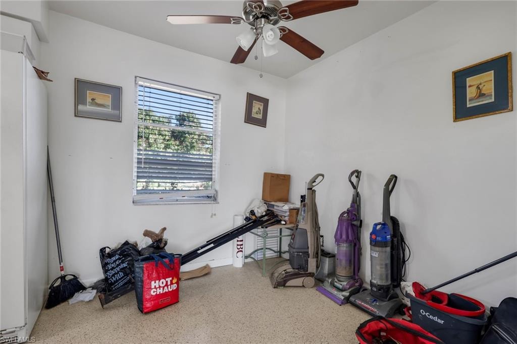 Recreation room featuring speckle patterned floor and ceiling fan