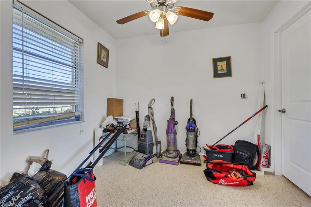 Recreation room with a ceiling fan and speckle patterned floor