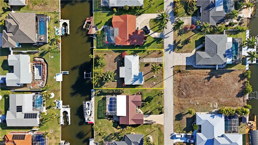 Aerial view of residential area featuring property parcel outlined and a large body of water