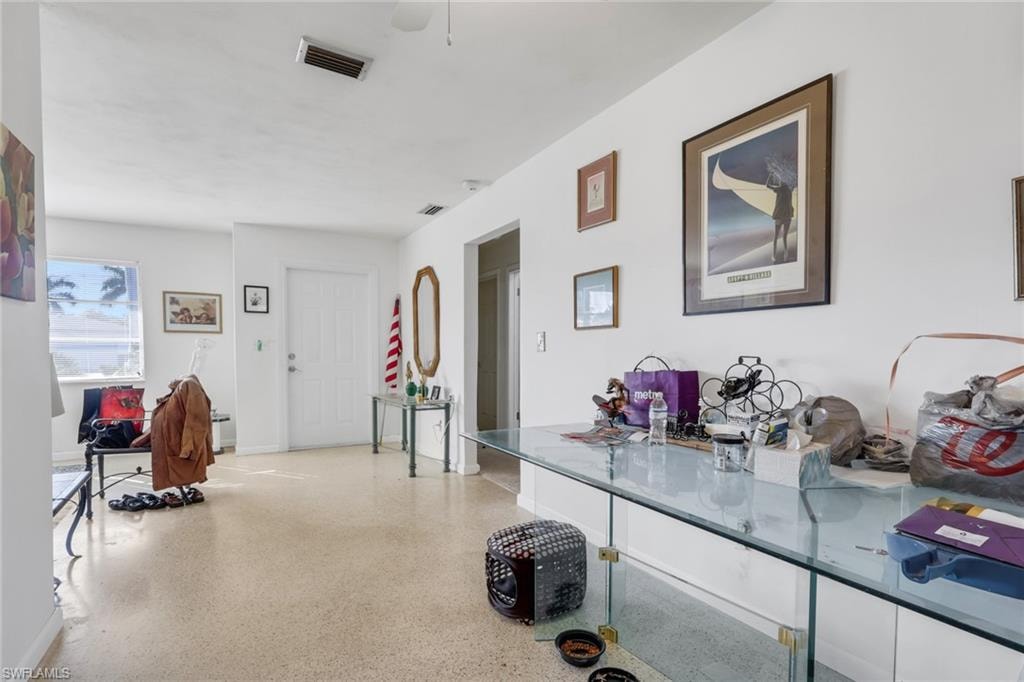 Hallway with dark aggregate flooring and baseboards