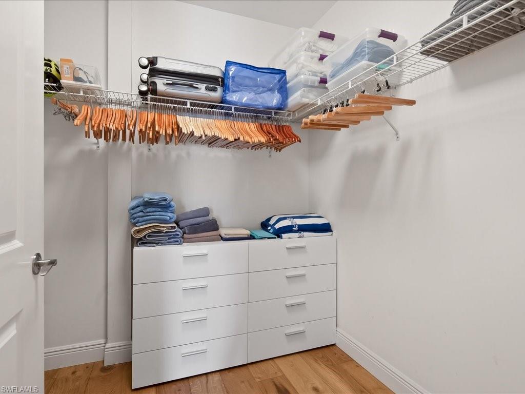 Walk in closet with light wood finished floors