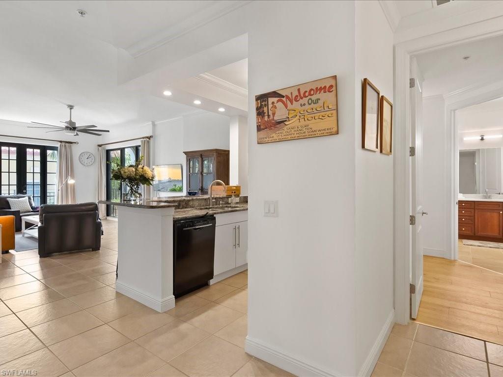 Kitchen with recessed lighting, ornamental molding, a ceiling fan, dishwasher, and dark stone countertops
