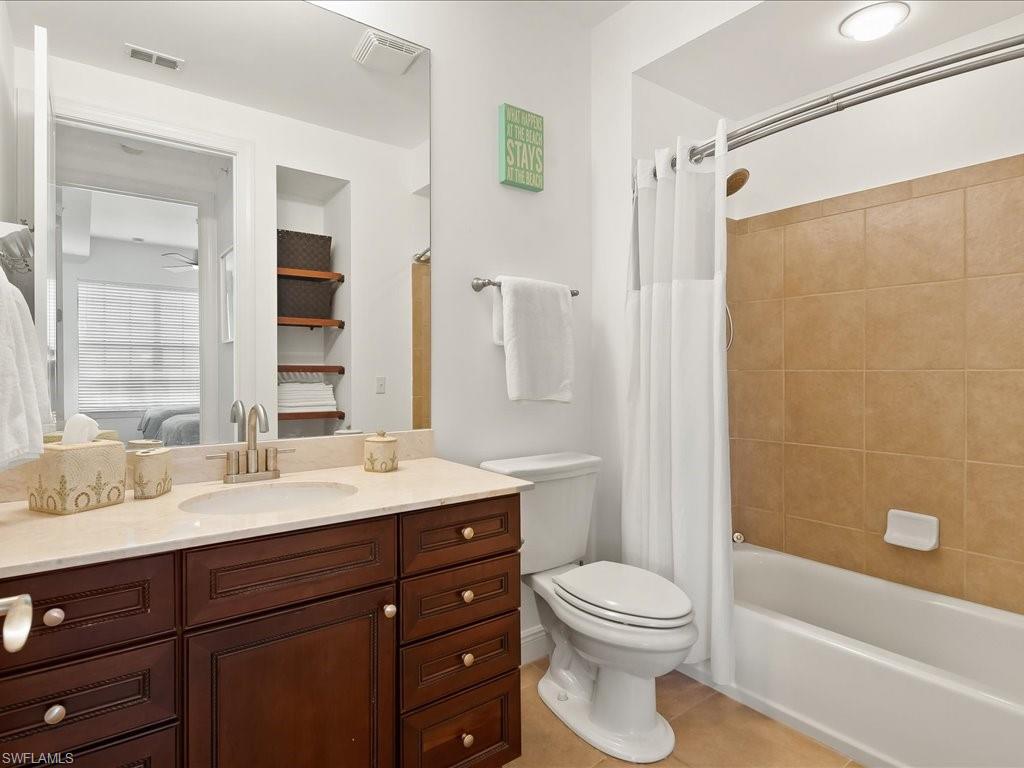 Ensuite bathroom with vanity, light tile patterned floors, and shower / bath combo