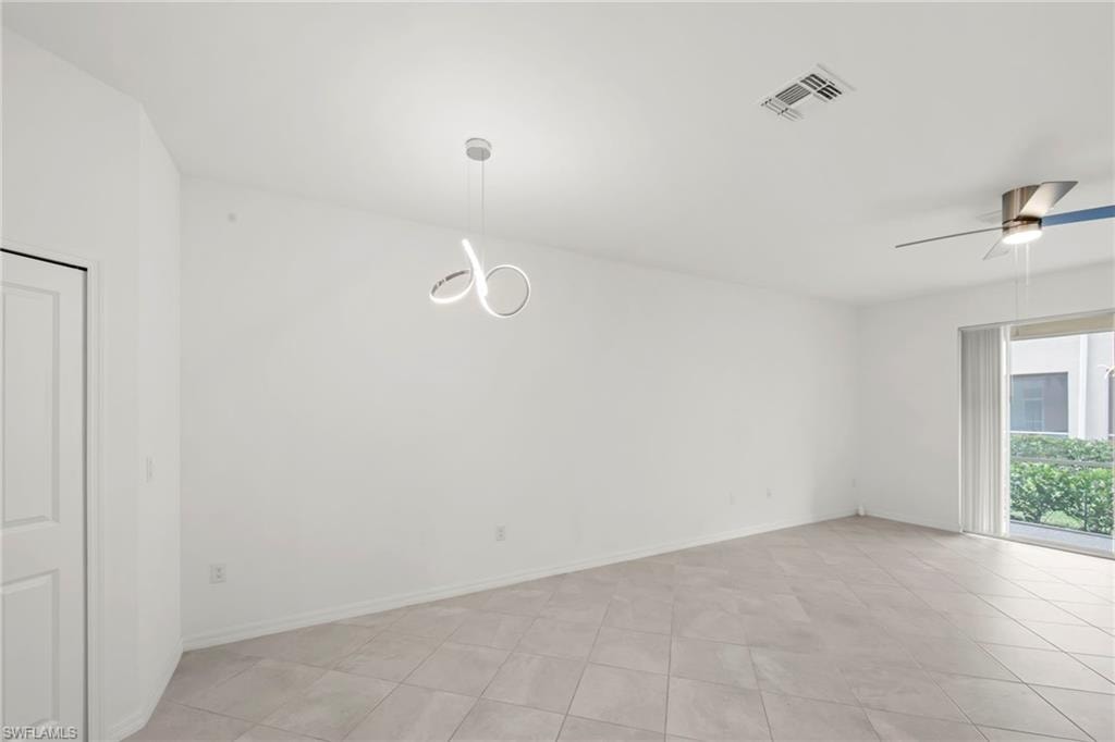 Empty room featuring a ceiling fan and light tile patterned floors