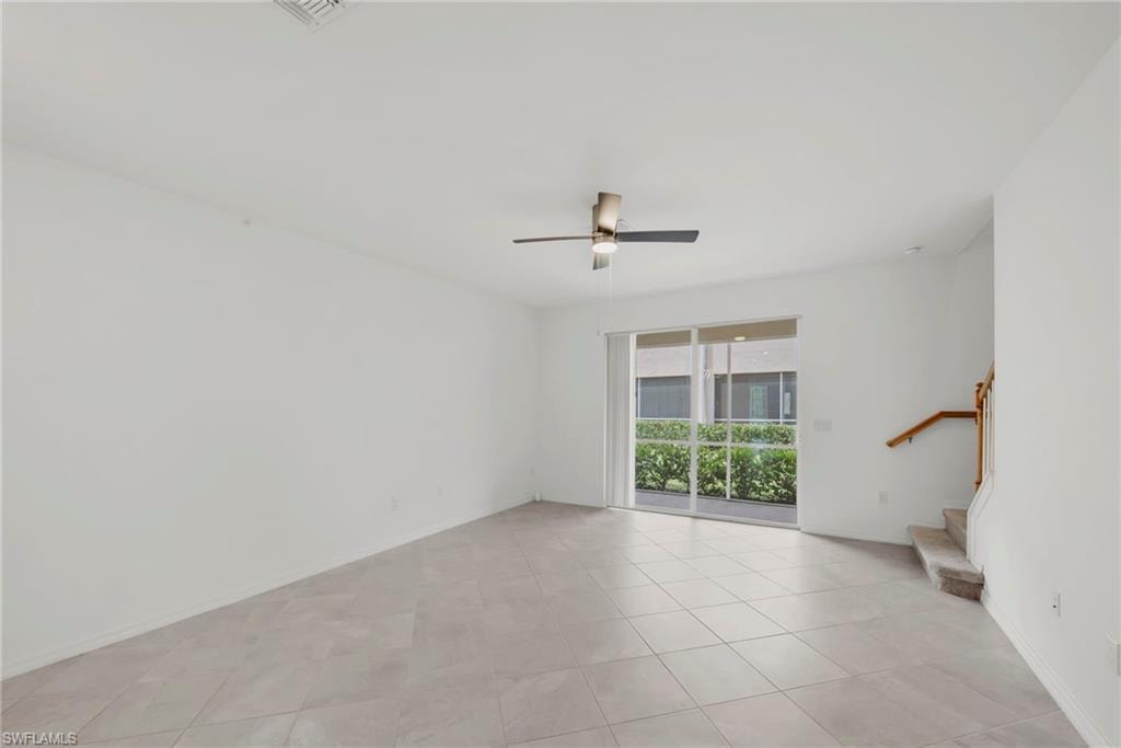 Empty room featuring light tile patterned floors and ceiling fan