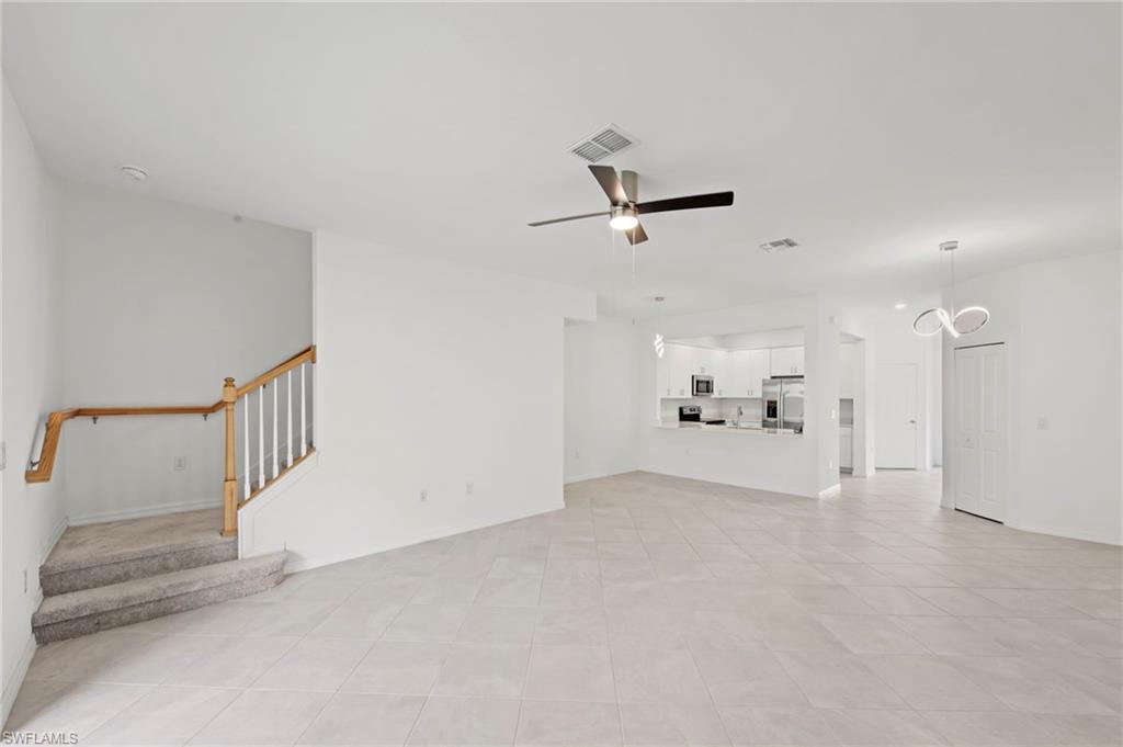 Unfurnished living room with ceiling fan and light tile patterned floors