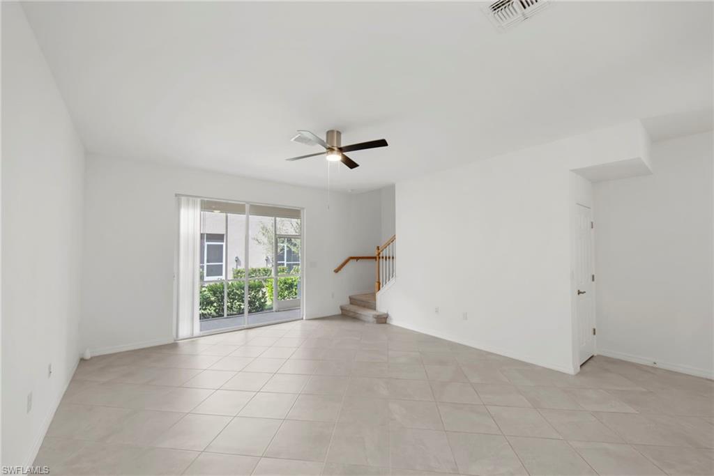 Empty room featuring a ceiling fan and light tile patterned flooring