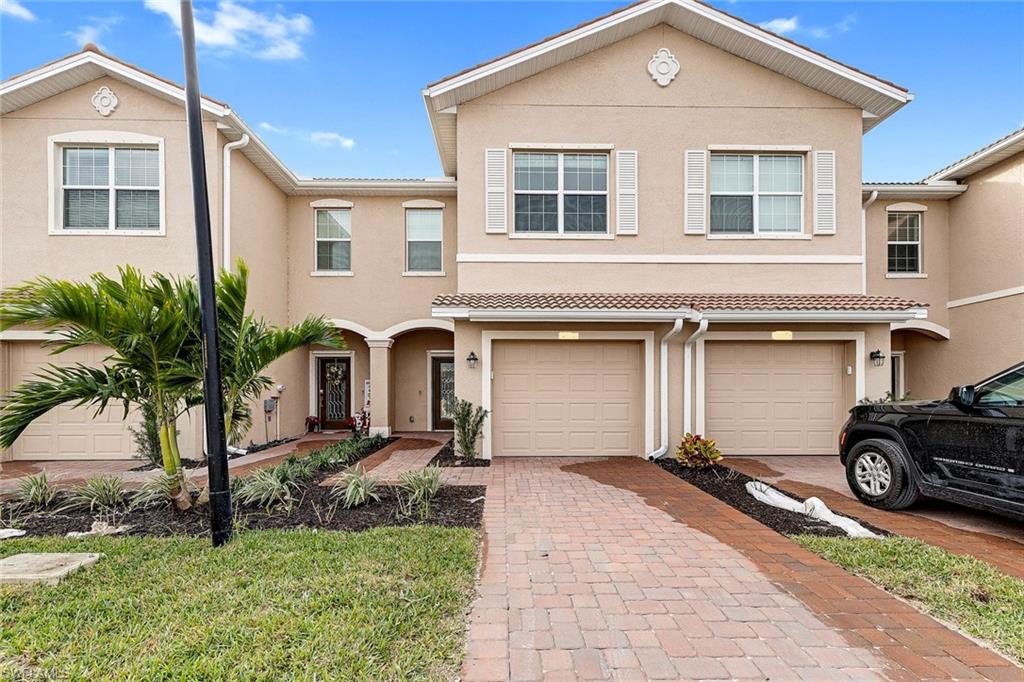Mediterranean / spanish home with stucco siding, decorative driveway, and an attached garage