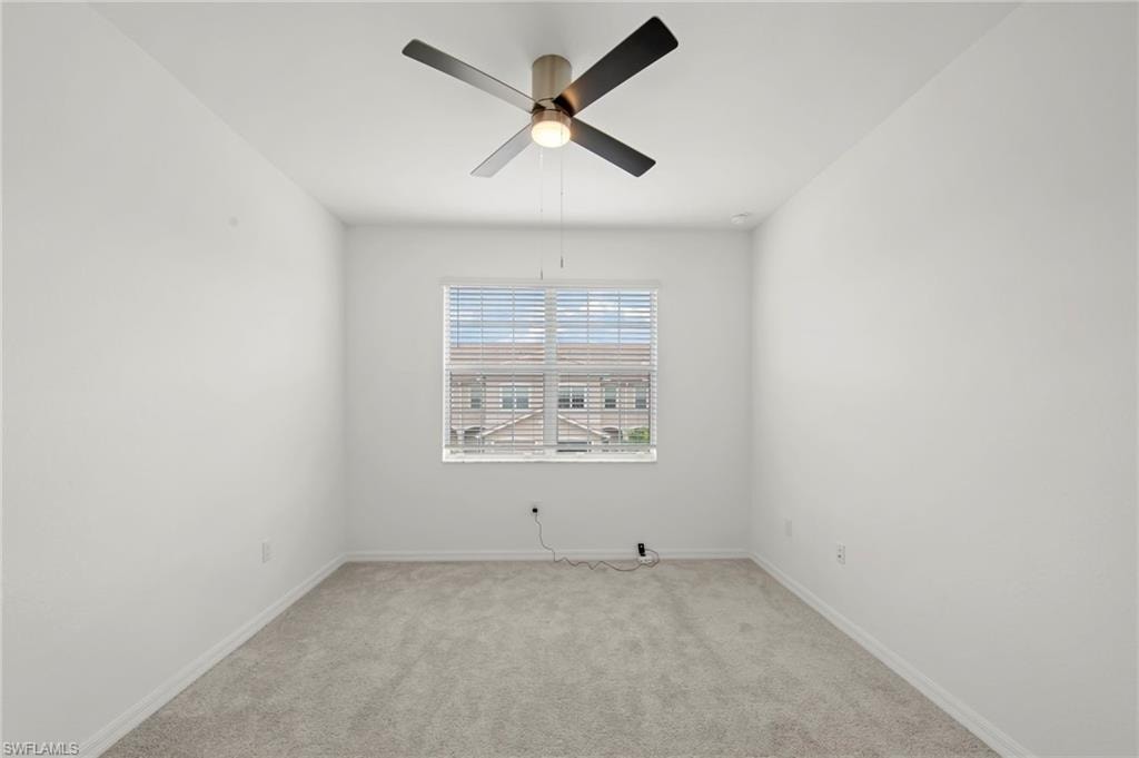Empty room with ceiling fan and carpet floors