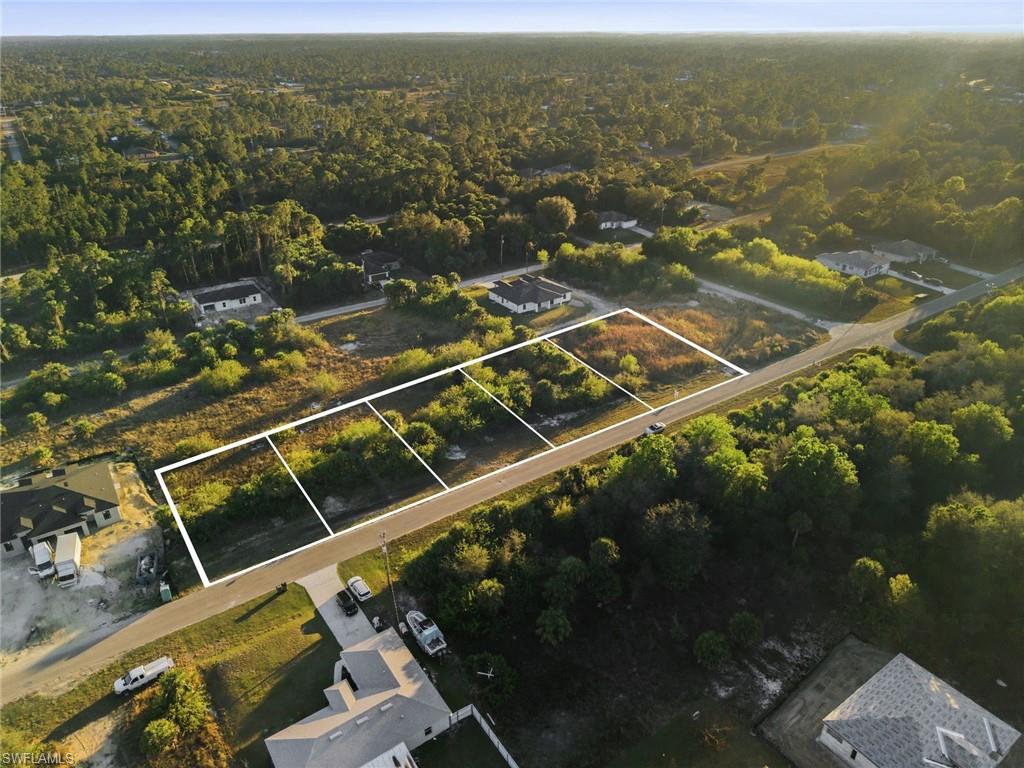 Aerial overview of property's location with a heavily wooded area and property parcel outlined