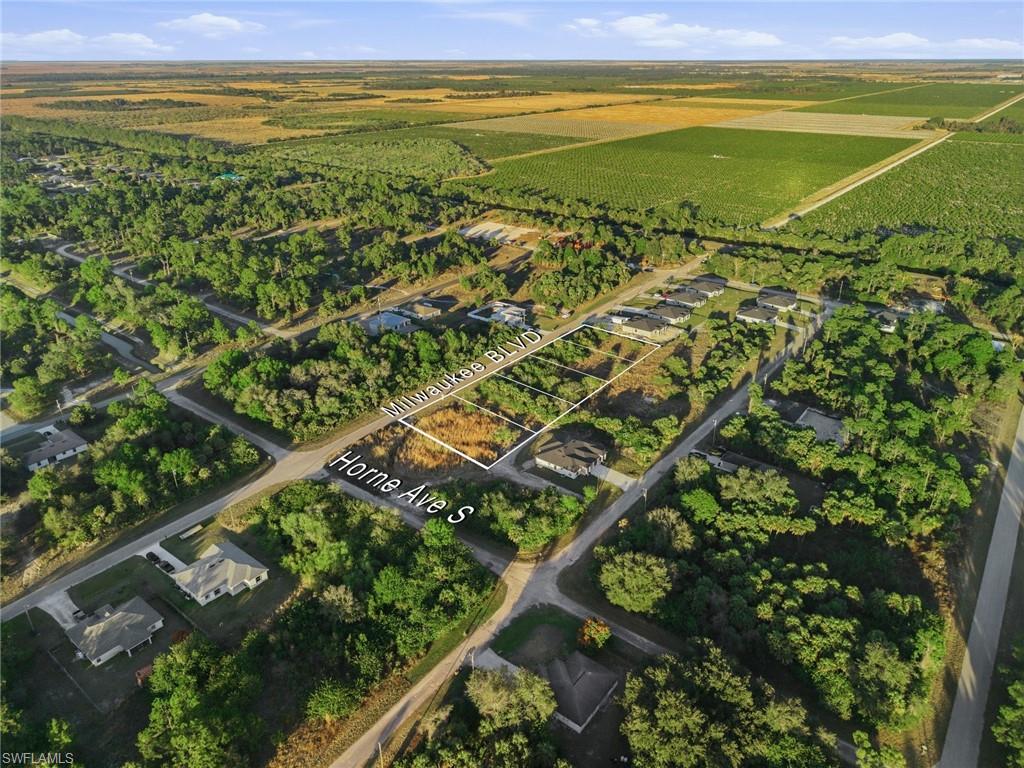 Aerial view of sparsely populated area with property parcel outlined and extensive farmland