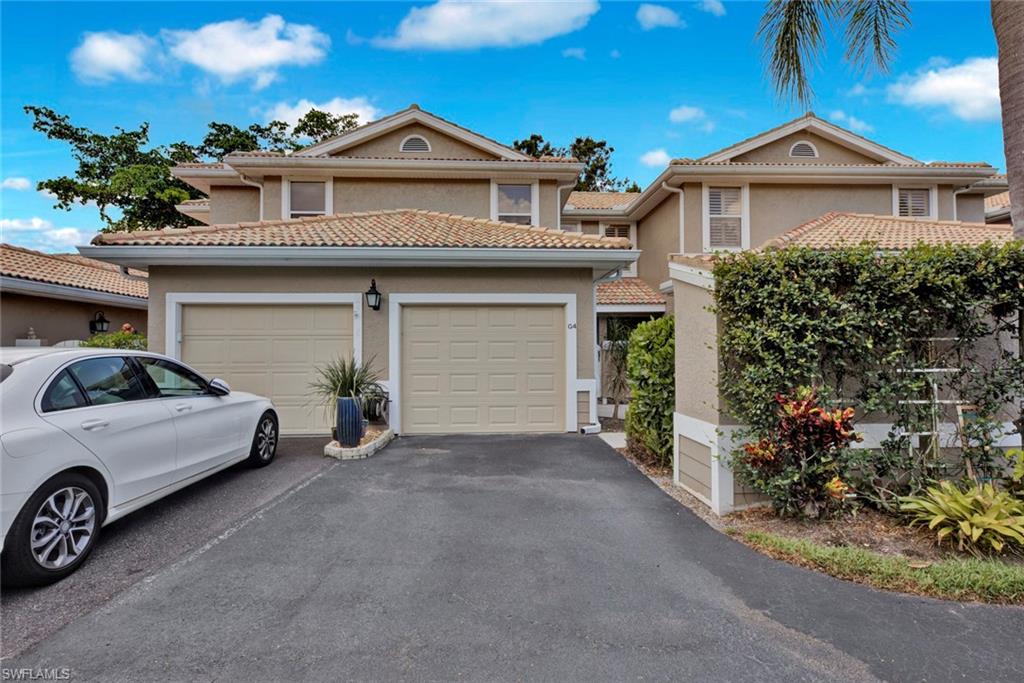 View of front of home featuring stucco siding, driveway, and a tiled roof