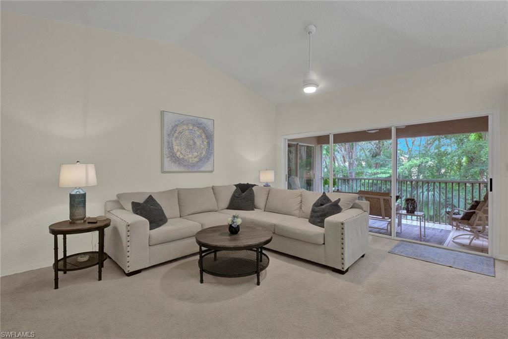 Living room featuring carpet and lofted ceiling