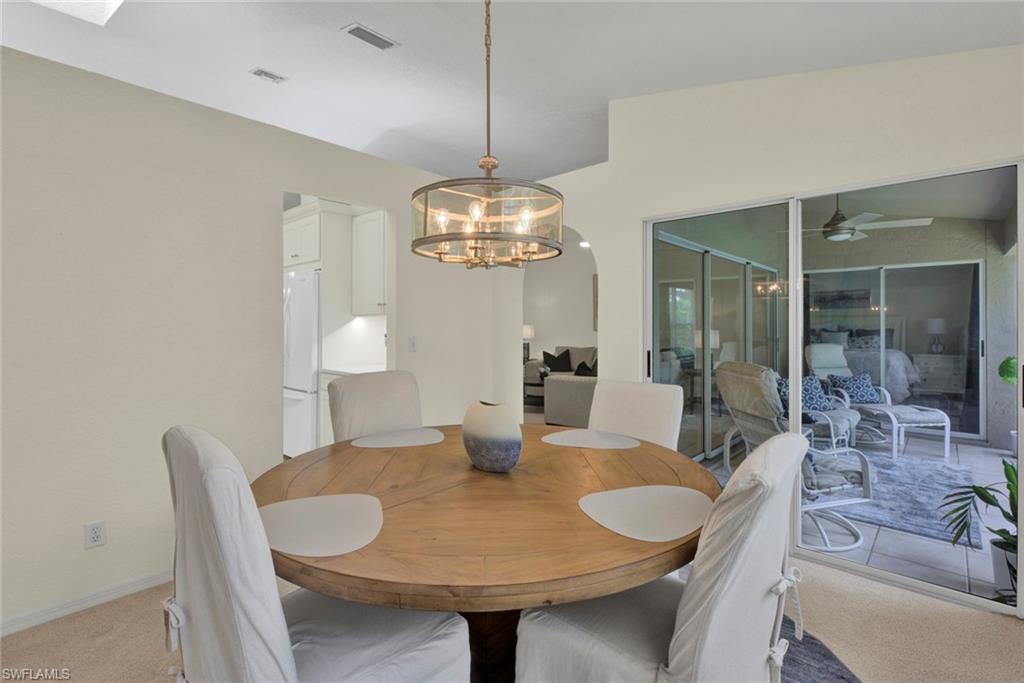 Dining space featuring light carpet, a ceiling fan, and hanging lights