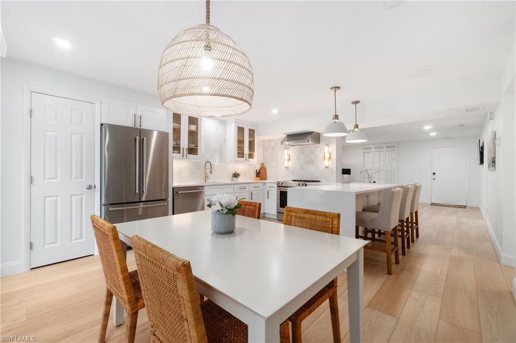 Dining room with light wood-style floors and recessed lighting