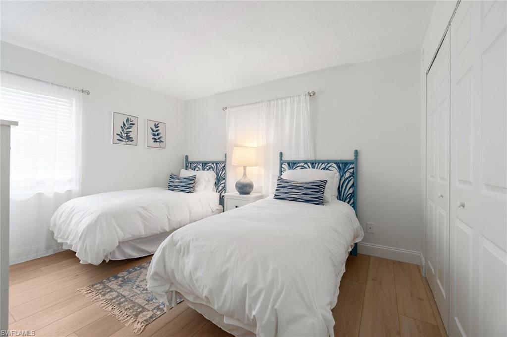 Bedroom featuring light wood-style floors, a closet, and multiple windows