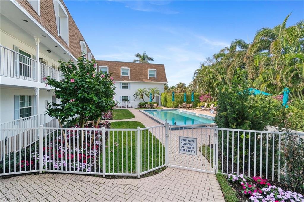 Community pool with a patio area and a gate