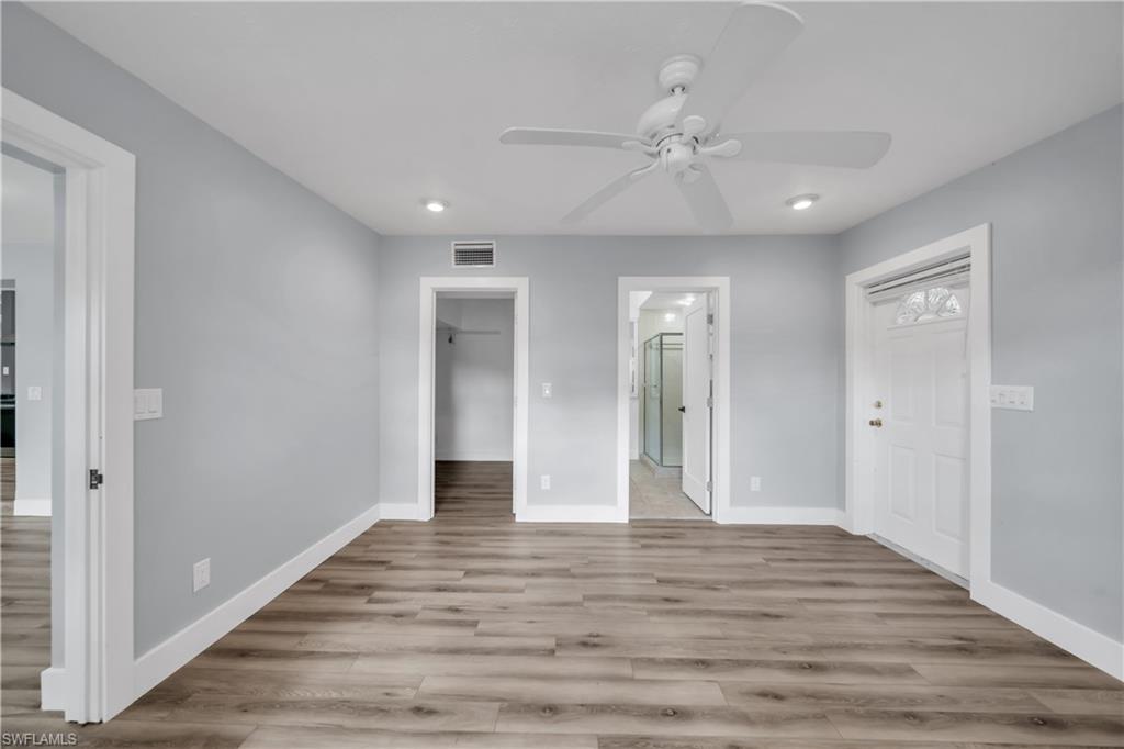 Unfurnished bedroom featuring a spacious closet, light wood-style flooring, connected bathroom, recessed lighting, and ceiling fan