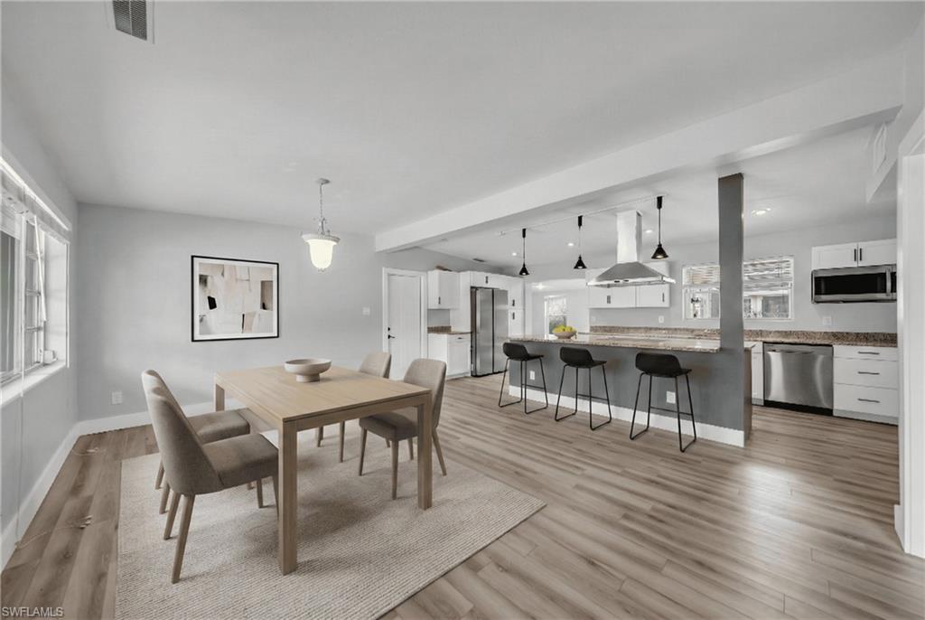 Dining area with light wood-style floors and recessed lighting