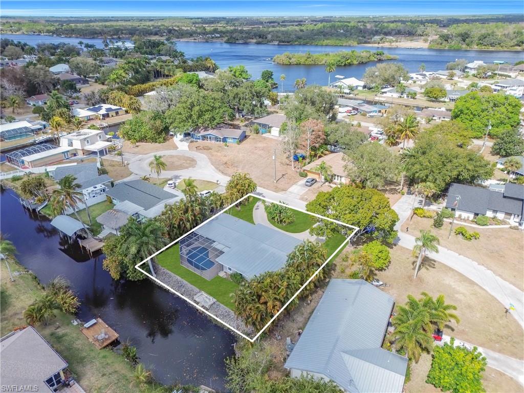 Aerial perspective of suburban area with a nearby body of water and property boundaries highlighted