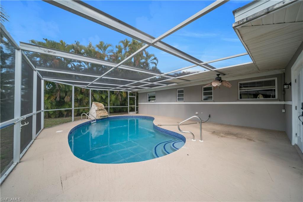 Swimming pool with a patio, a sunroom, and glass enclosure