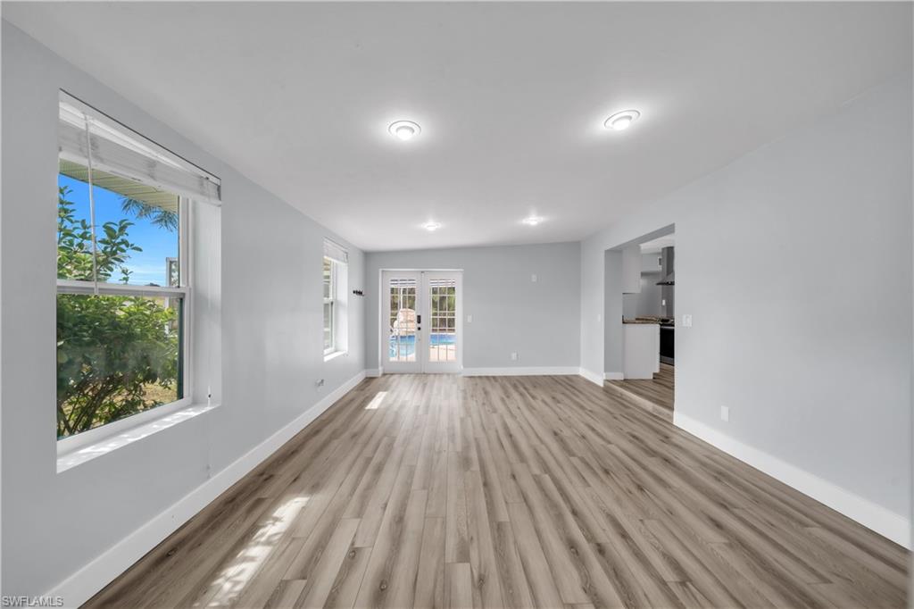 Unfurnished living room featuring french doors and wood finished floors
