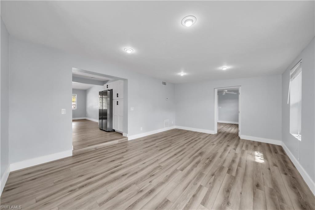 Unfurnished living room featuring baseboards and light wood finished floors