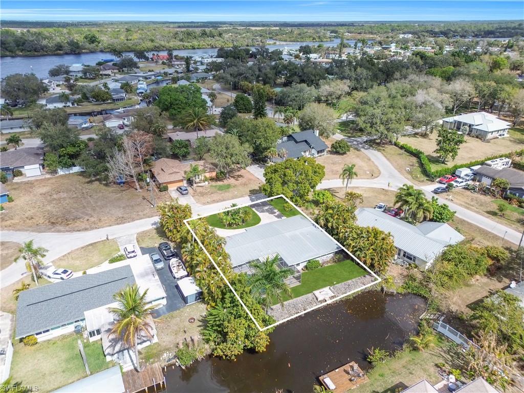 Aerial perspective of suburban area featuring a nearby body of water and property parcel outlined