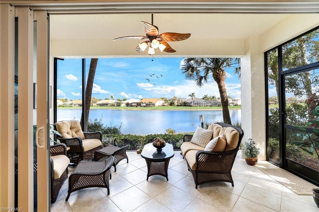 Sunroom / solarium featuring a residential view, tile patterned floors, and a water view