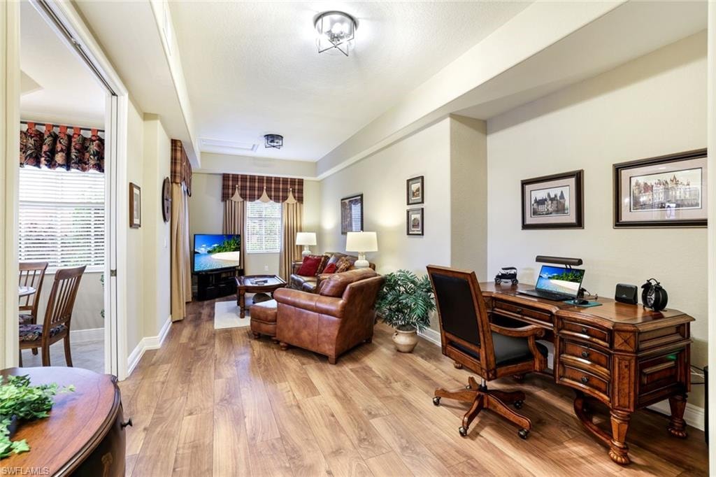Home office with light wood-type flooring and baseboards