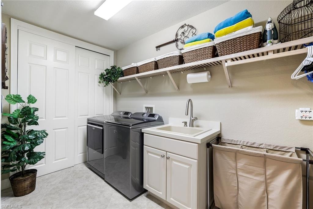 Laundry area featuring washing machine and dryer and cabinet space