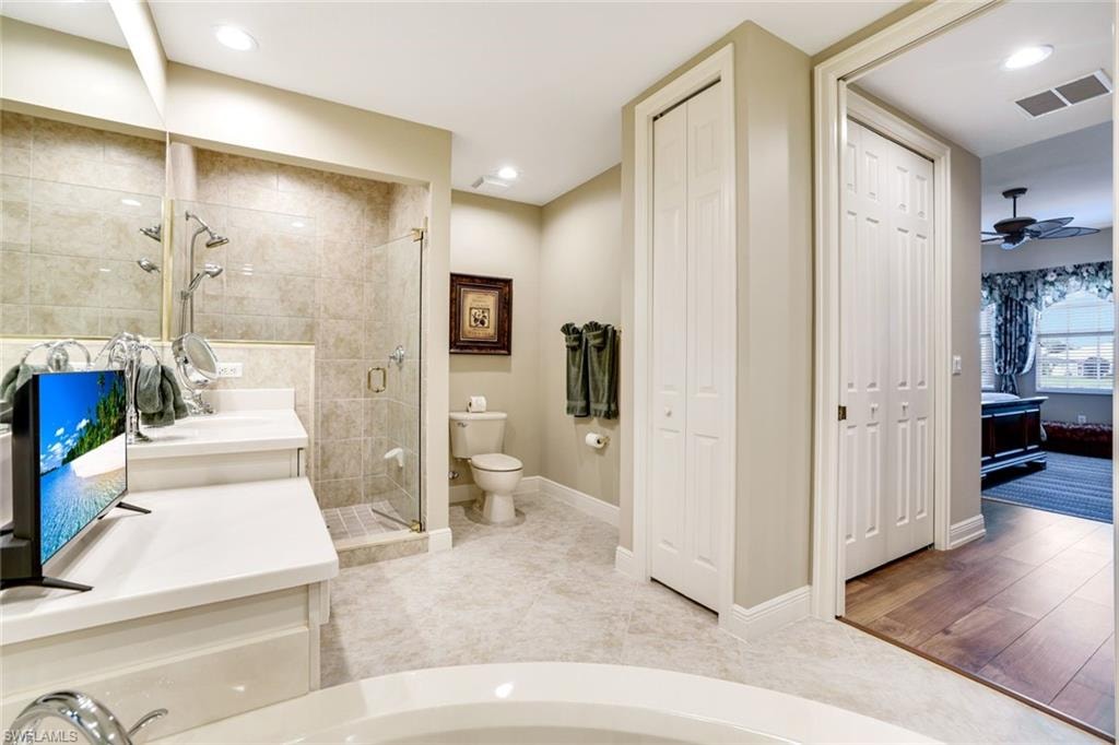 Full bathroom with a closet, vanity, a stall shower, ceiling fan, and recessed lighting