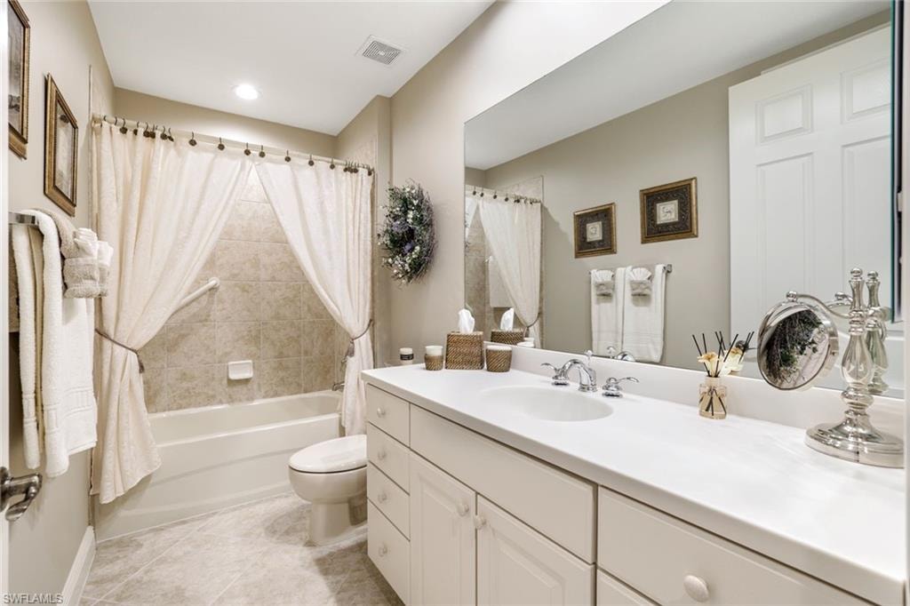 Full bathroom with shower / bath combo, vanity, and light tile patterned floors