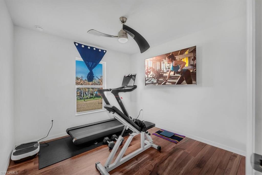 Exercise area featuring wood finished floors and a ceiling fan