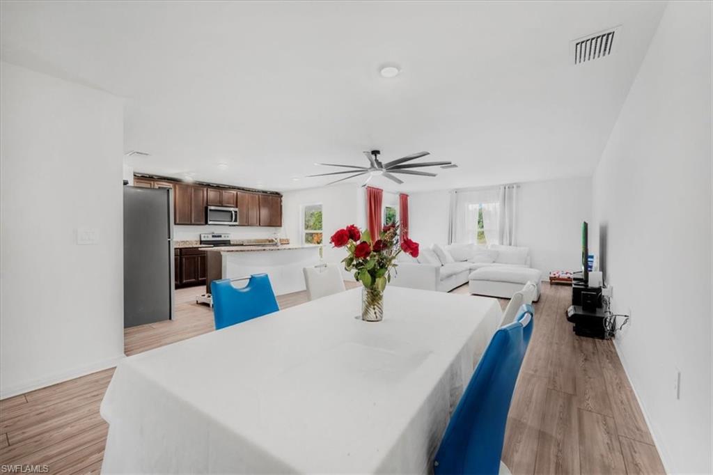 Dining area featuring light wood-style floors, ceiling fan, and recessed lighting