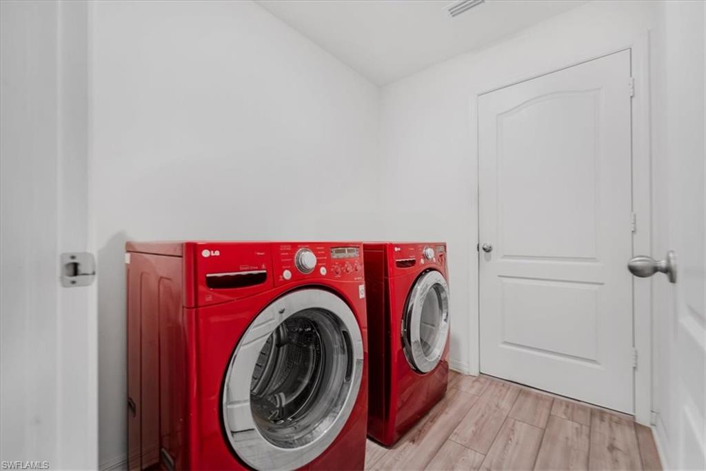 Laundry room featuring independent washer and dryer and wood finished floors