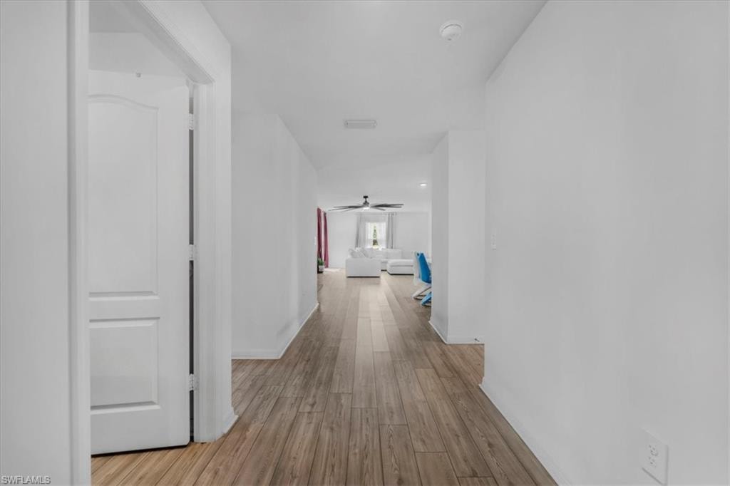 Hallway with light wood finished floors and baseboards