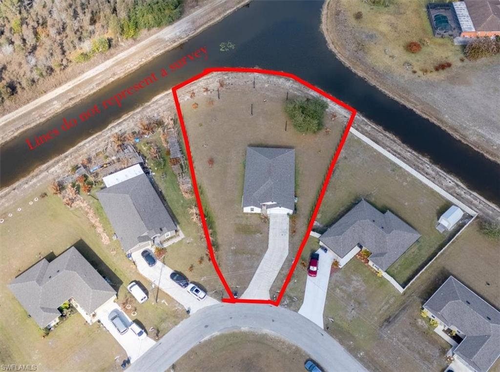 Aerial perspective of suburban area with a nearby body of water and property boundaries highlighted