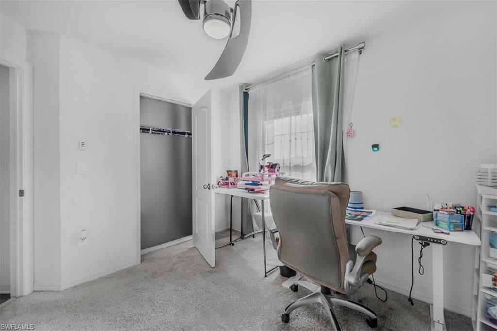 Home office featuring light carpet and baseboards